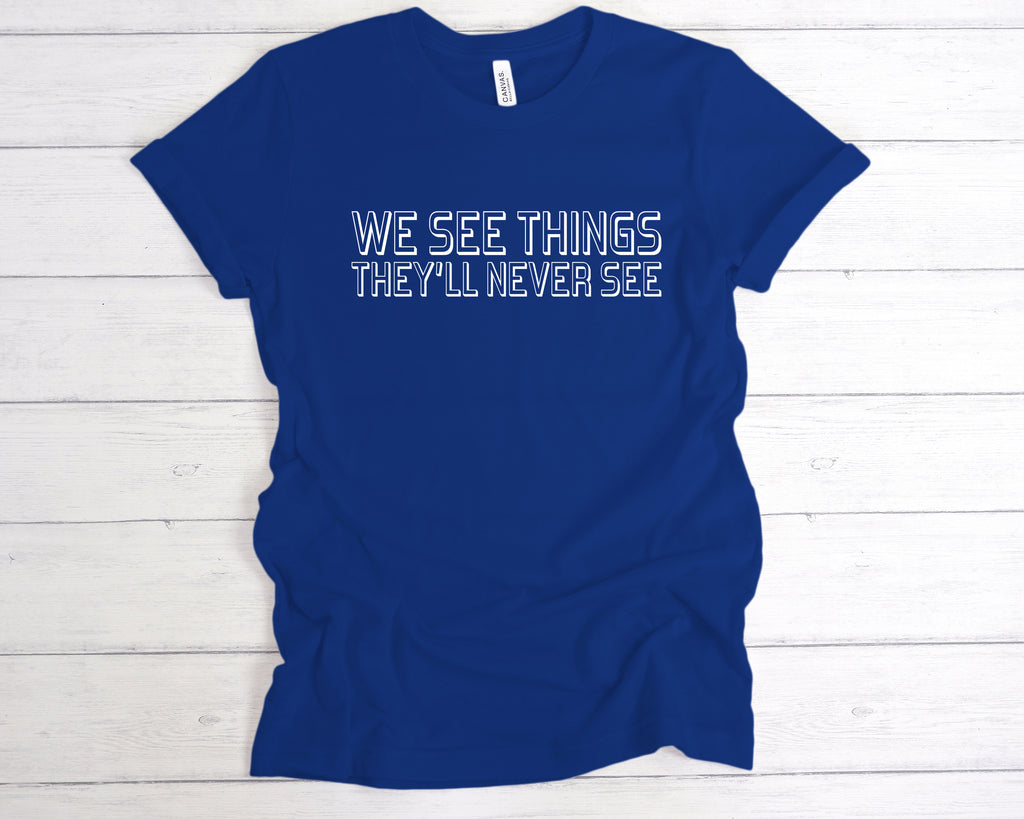 Royal Blue unisex band-style t-shirt featuring the bold slogan "We See Things They’ll Never See" across the chest in a clean, concert-style font. This edgy alternative tee is perfect for music lovers, gig-goers, and fans of underground fashion. Made from soft cotton, it’s ideal for concerts, festivals, or as part of a rock-inspired wardrobe. A great gift for anyone who lives for live music and alternative culture.